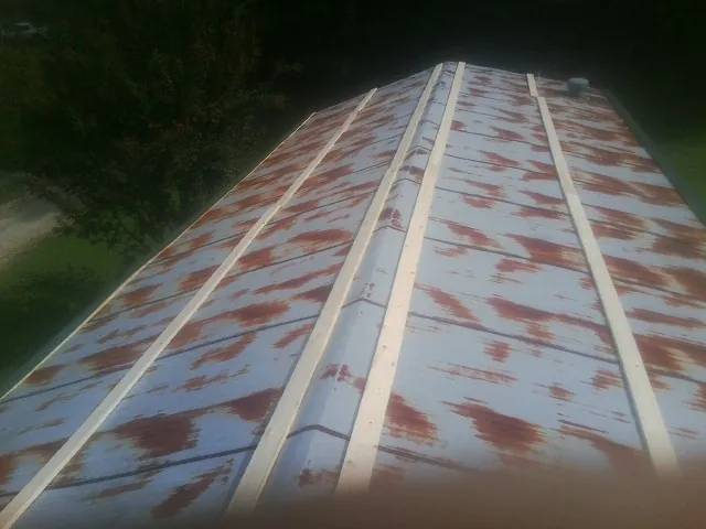 Rusted metal roof panels with new wood purlins before replacement — Storm Damage Roof Repair in Amberson by Roofing Brothers