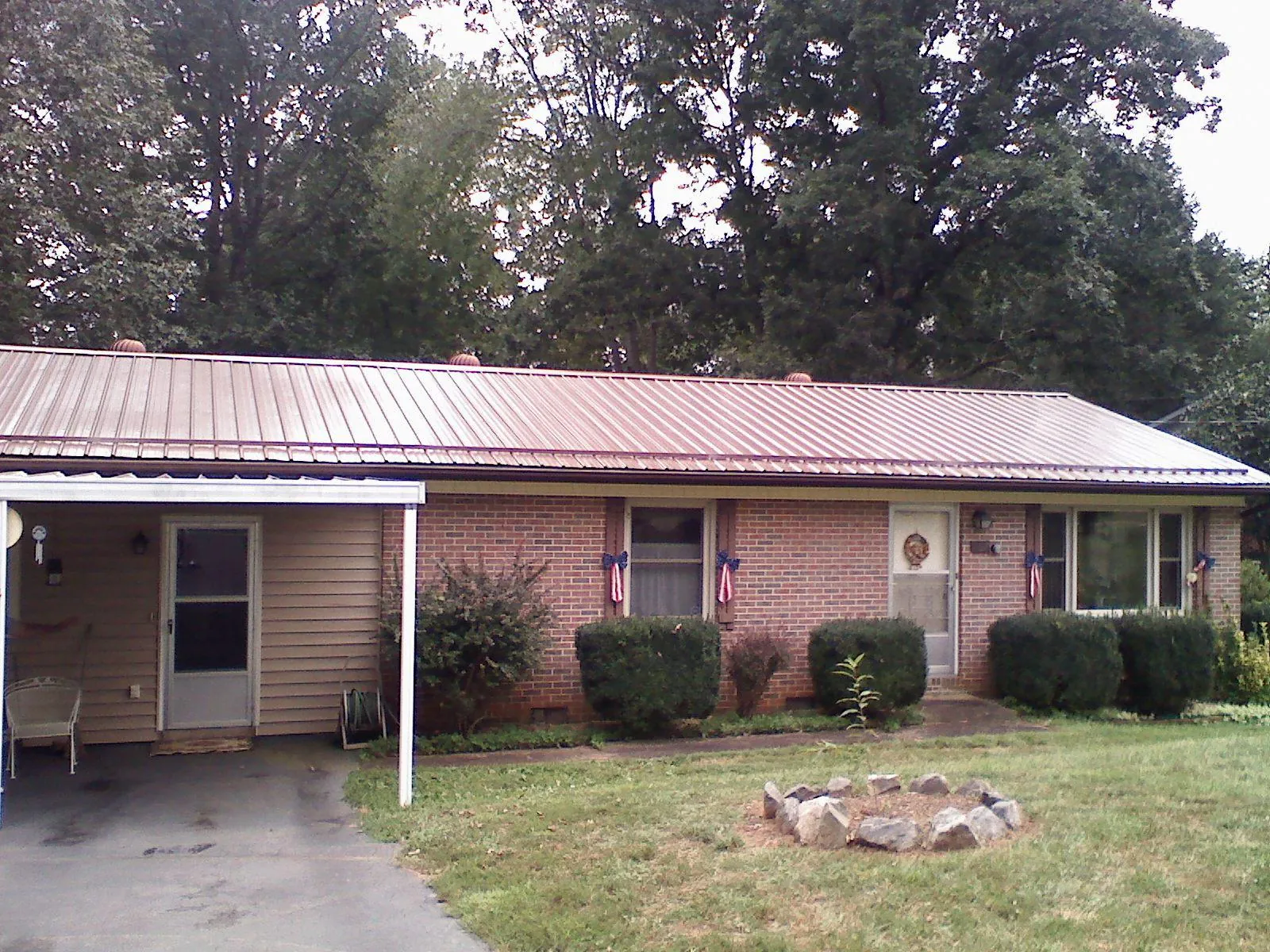 Bronze metal roof and carport on a brick ranch home — Roof Repair work by our crew in Amberson