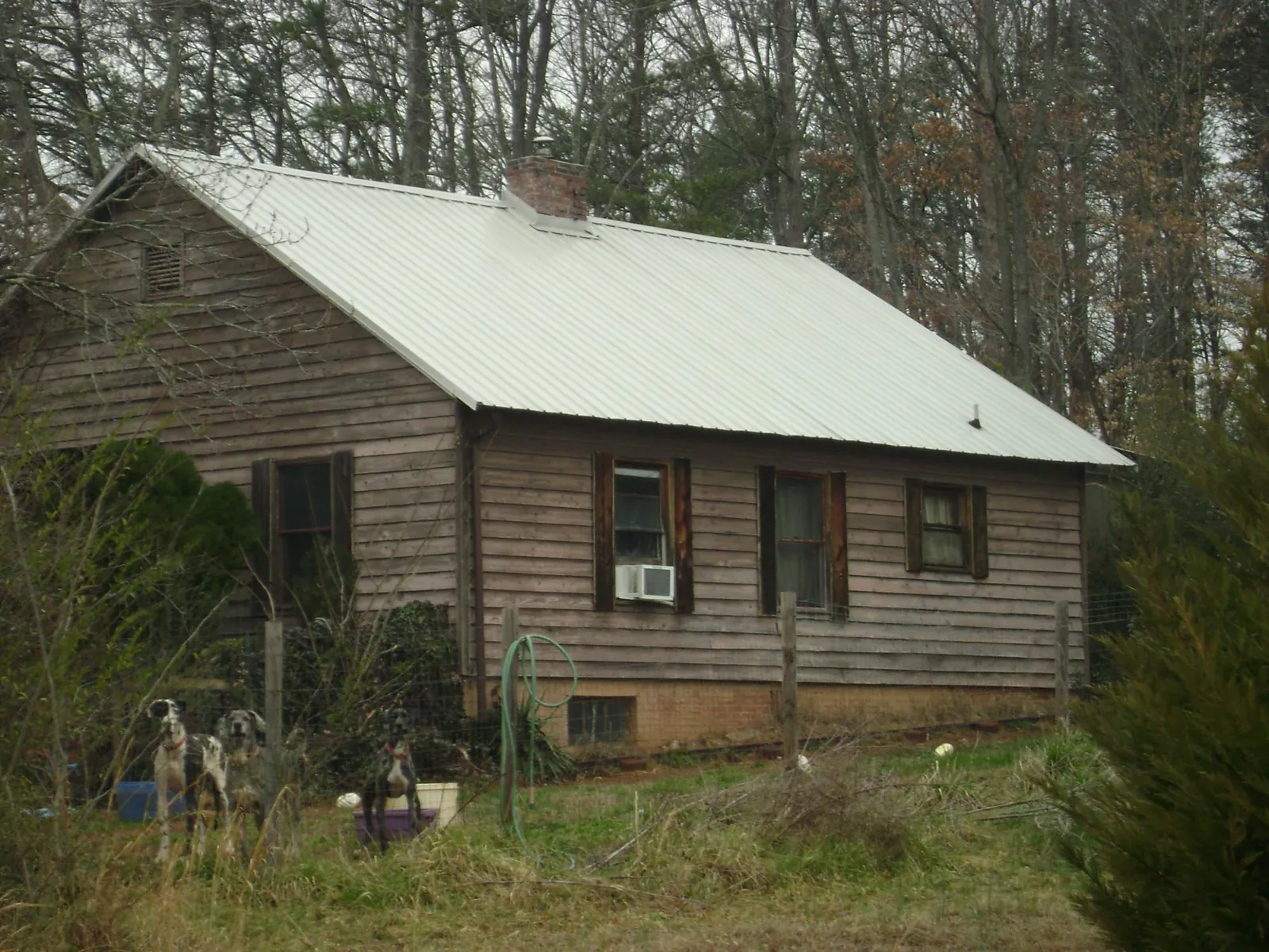 White metal roof on an old wood sided farmhouse, from a Metal Roof Installation job in Amberson